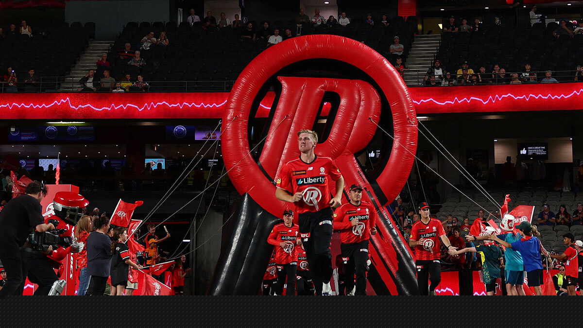 Melbourne Renegades players entering the field beneath the club's giant red R logo during a Big Bash match