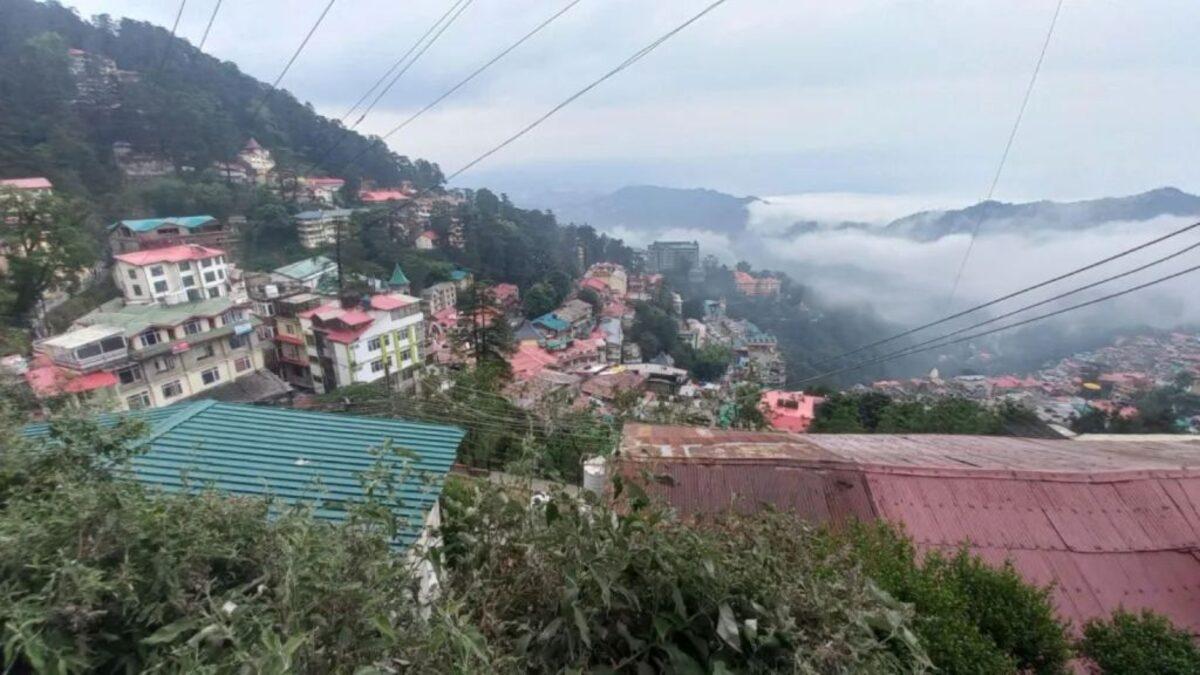 Homes and hills in Himachal Pradesh under a cloudy sky