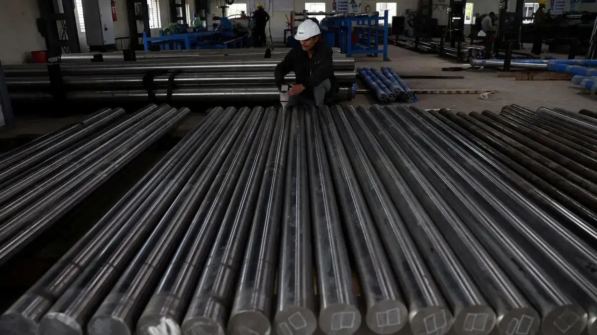 A worker checks steel bars inside a factory near Ahmedabad, India