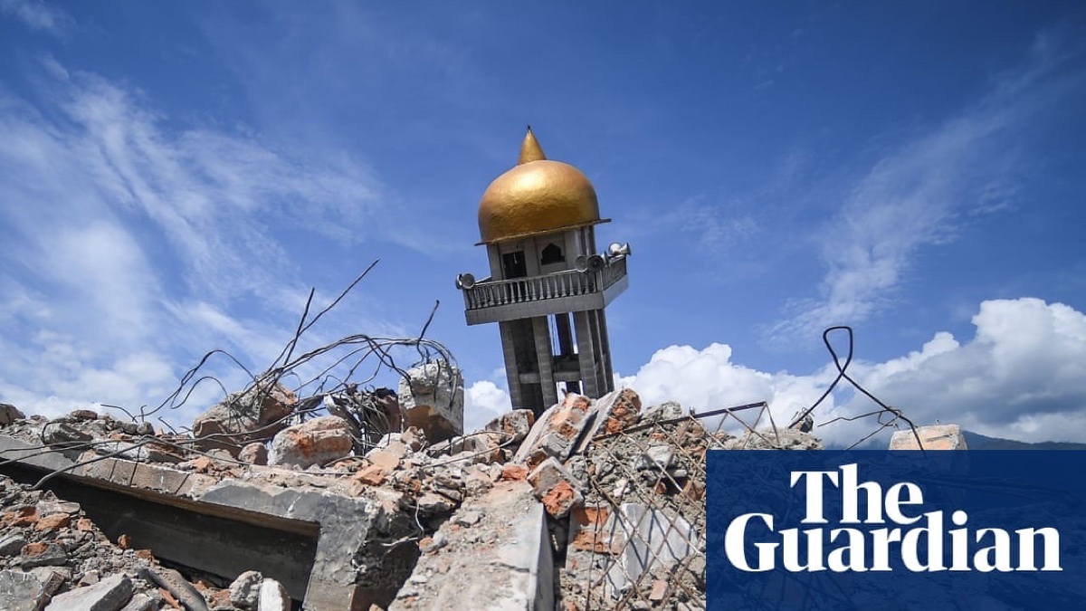 A mosque loudspeaker tower above homes in an Indonesian community