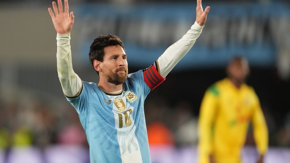 Lionel Messi raises both arms while wearing Argentina's number 10 shirt