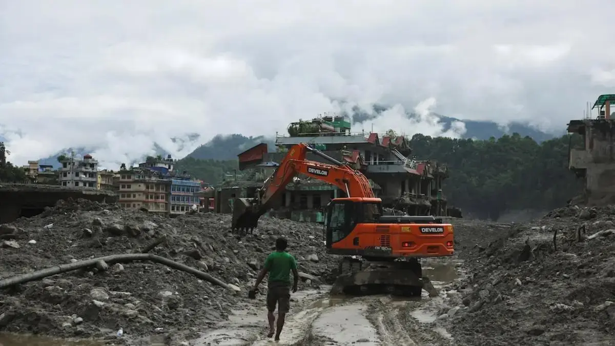 An excavator clears mud after flash floods in Trishuli, Nuwakot district, Nepal