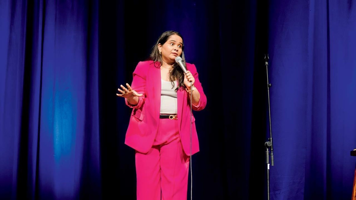 Comedian Sumukhi Suresh performing on stage with a microphone