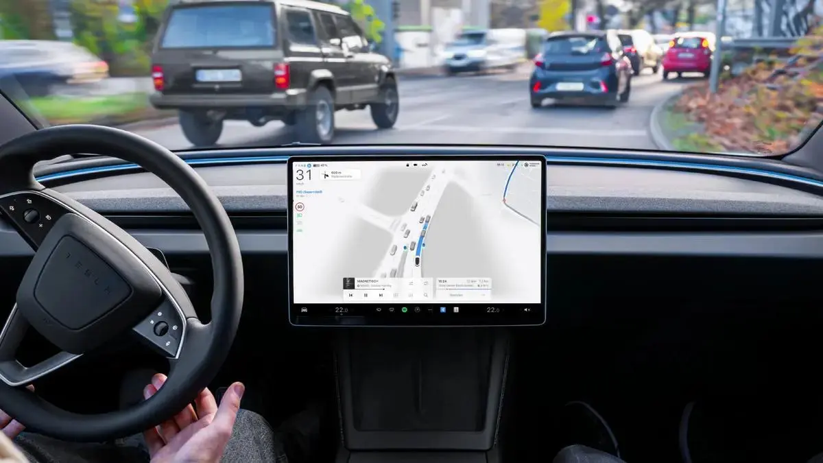 A driver supervising Tesla Full Self-Driving on a European road