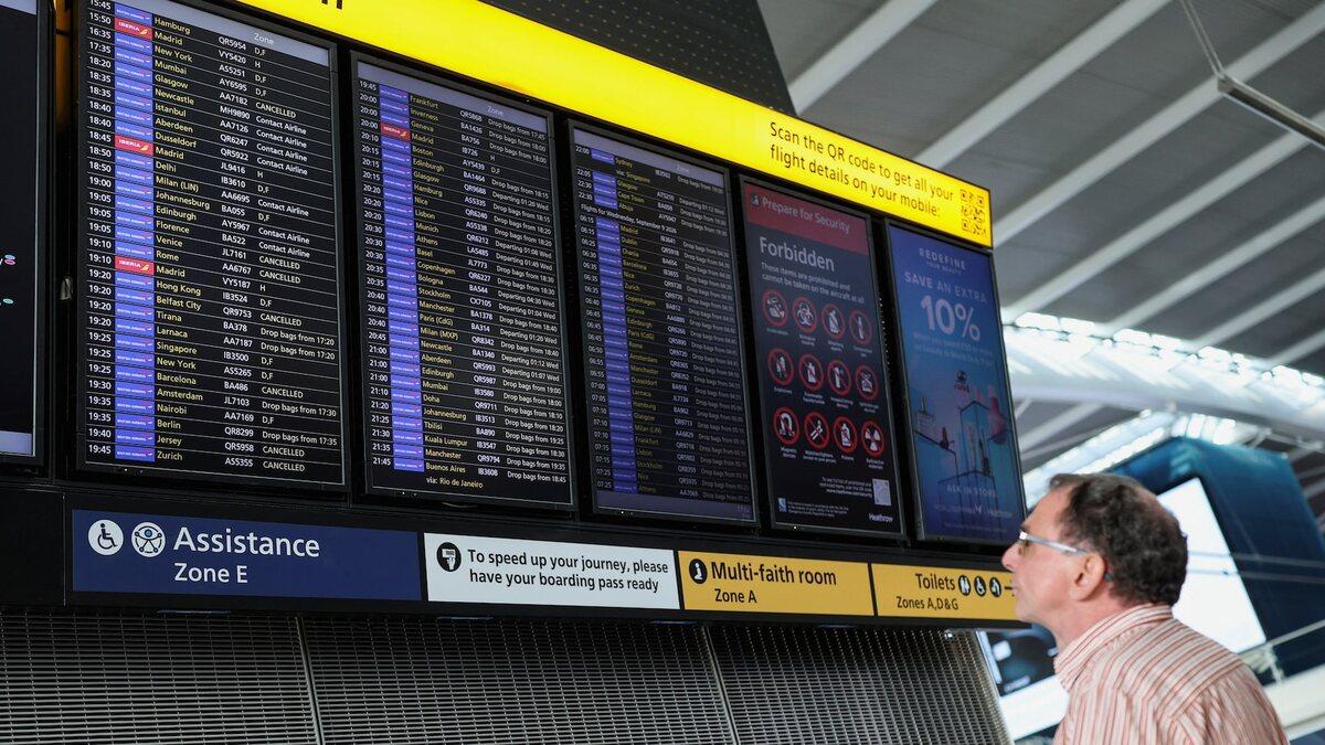 Passenger checking a Heathrow Terminal 5 departure board showing cancelled flights on September 8, 2026