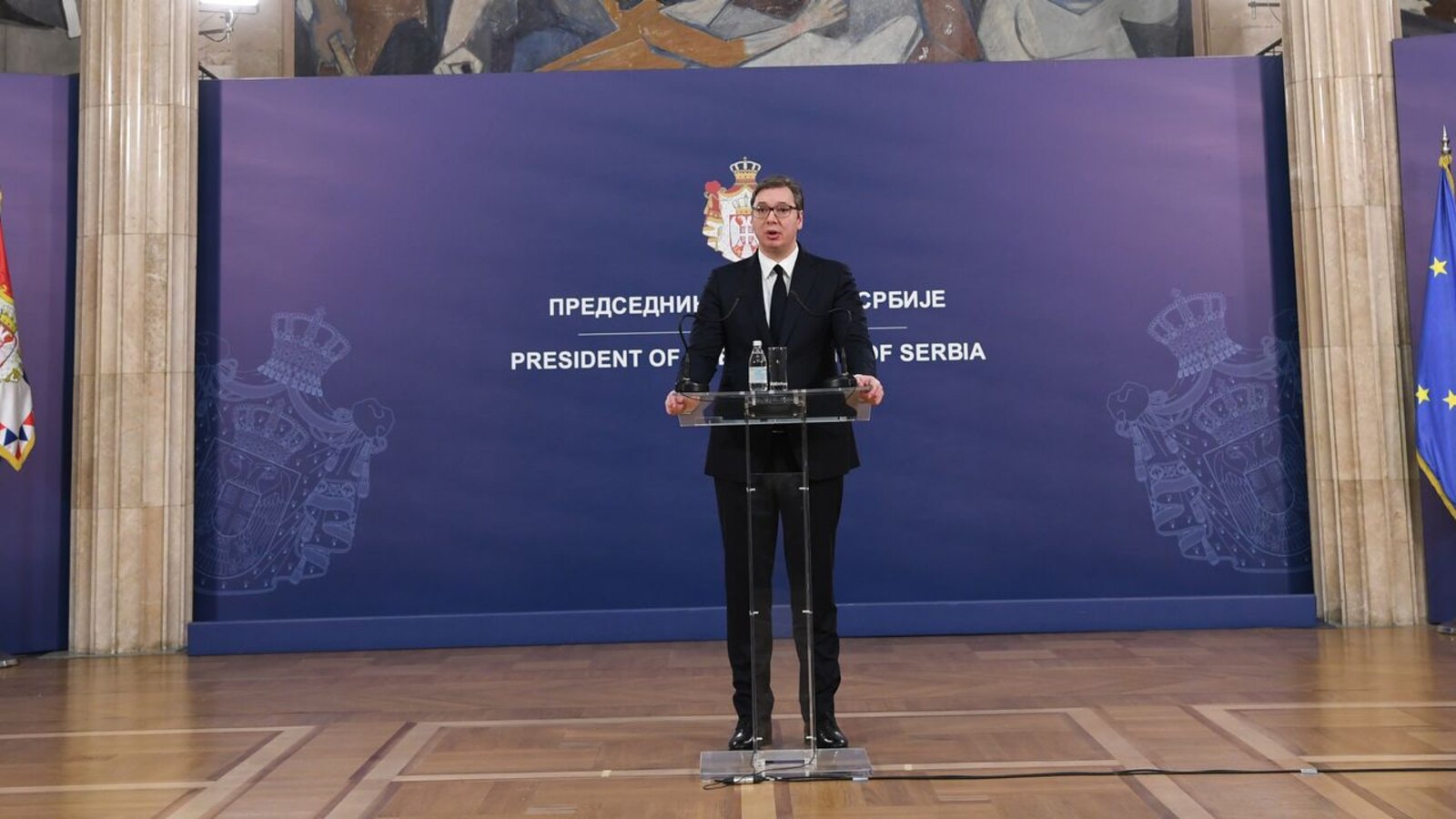 Aleksandar Vucic speaking at a podium beside the Serbian flag in an official presidency photograph